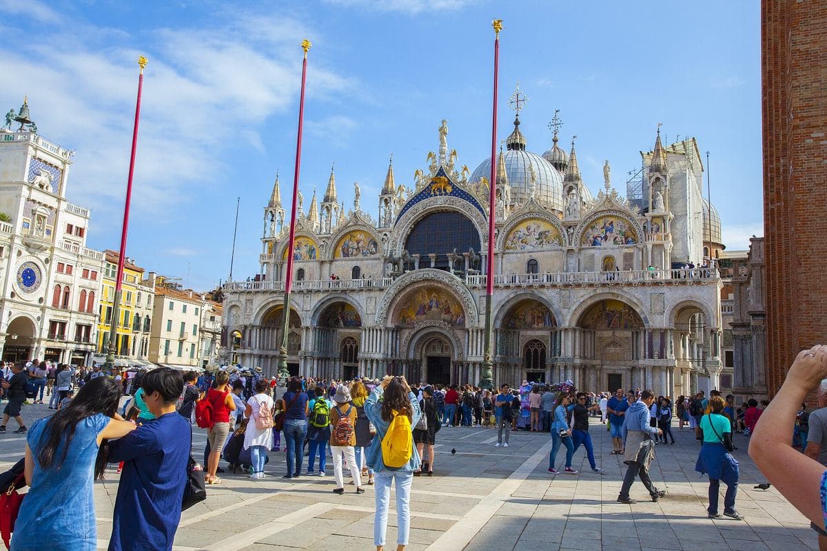 The west front of St Mark's Basilica across a busy St Mark's Square